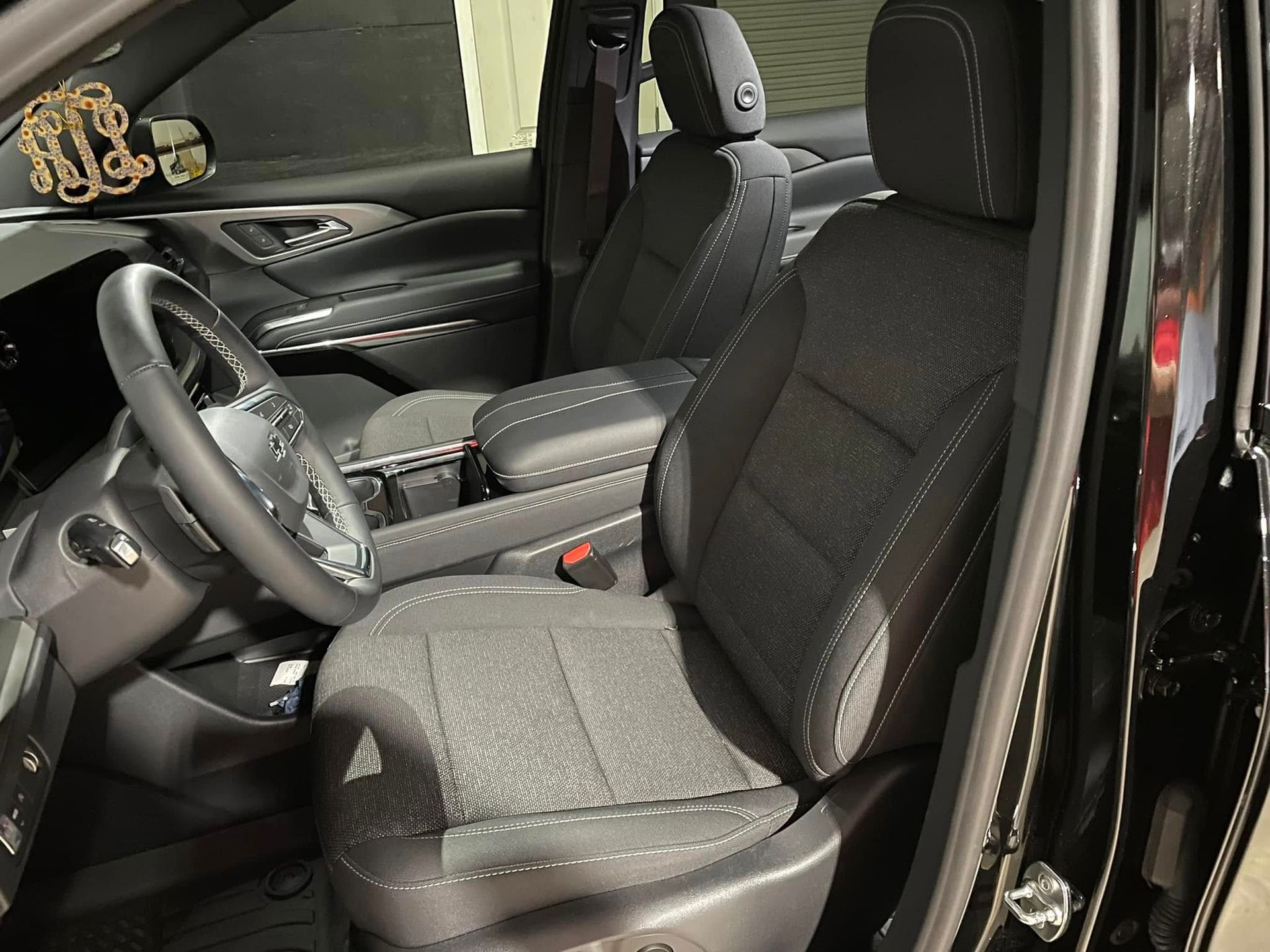 The inside of a black car with a steering wheel and seats
