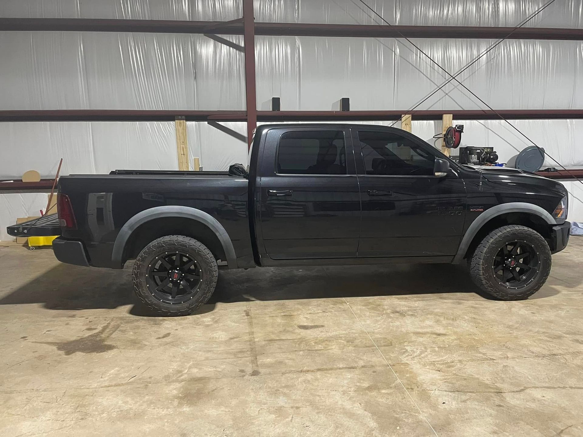 A black truck is parked in a garage.