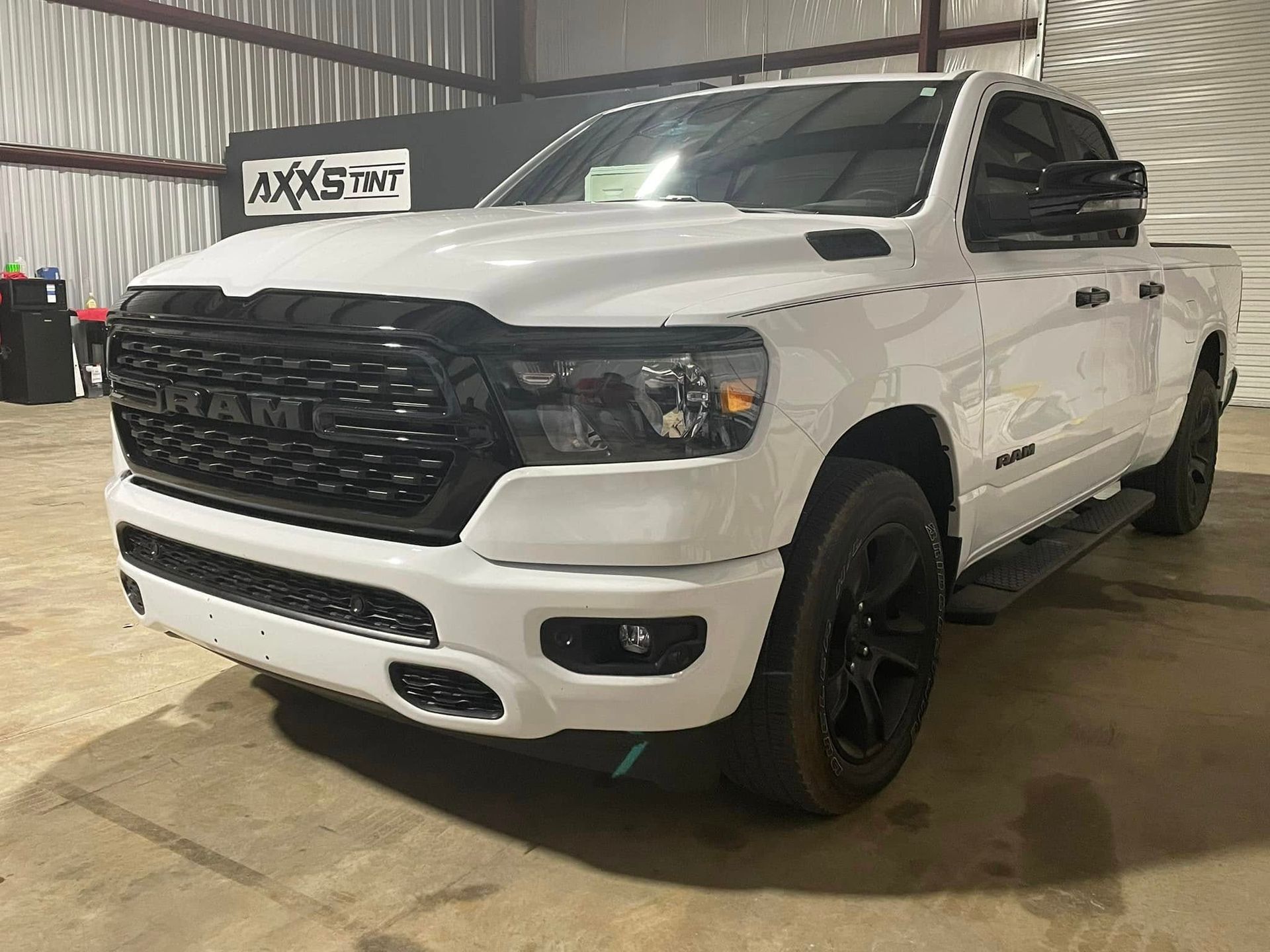 A white ram 1500 truck is parked in a garage.