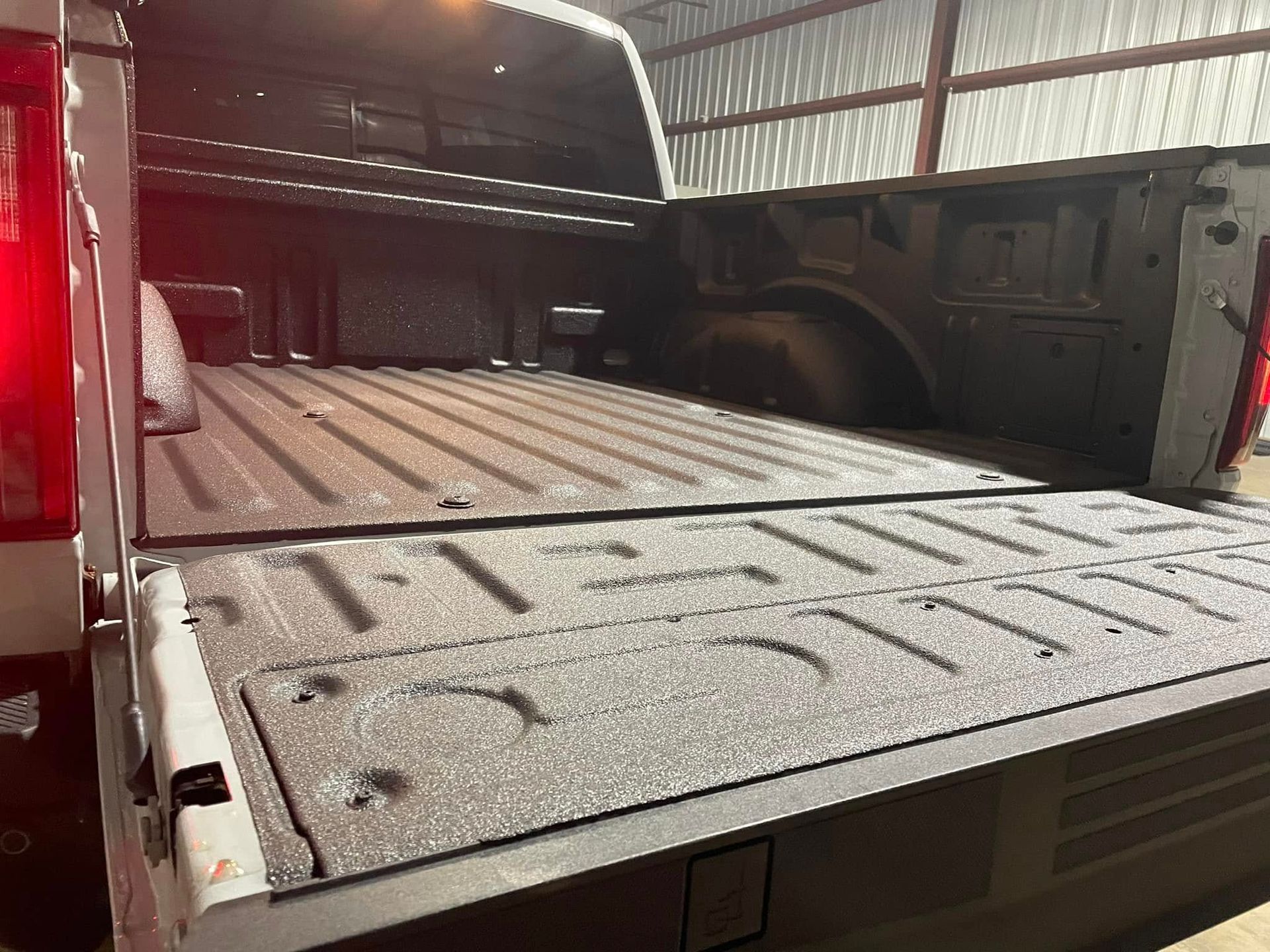 The back of a truck with the bed open and the tailgate open.