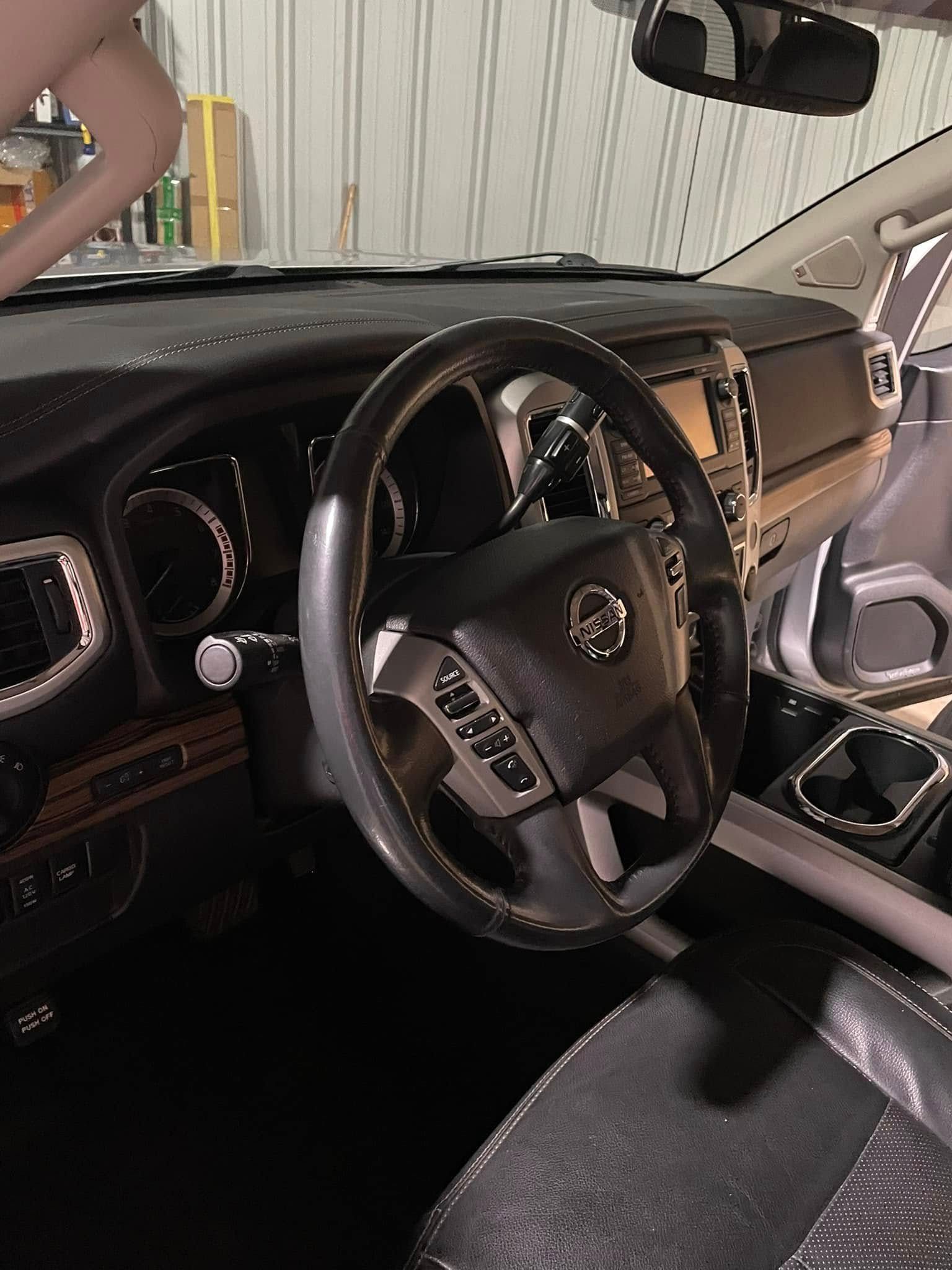 The inside of a car with a steering wheel and dashboard.