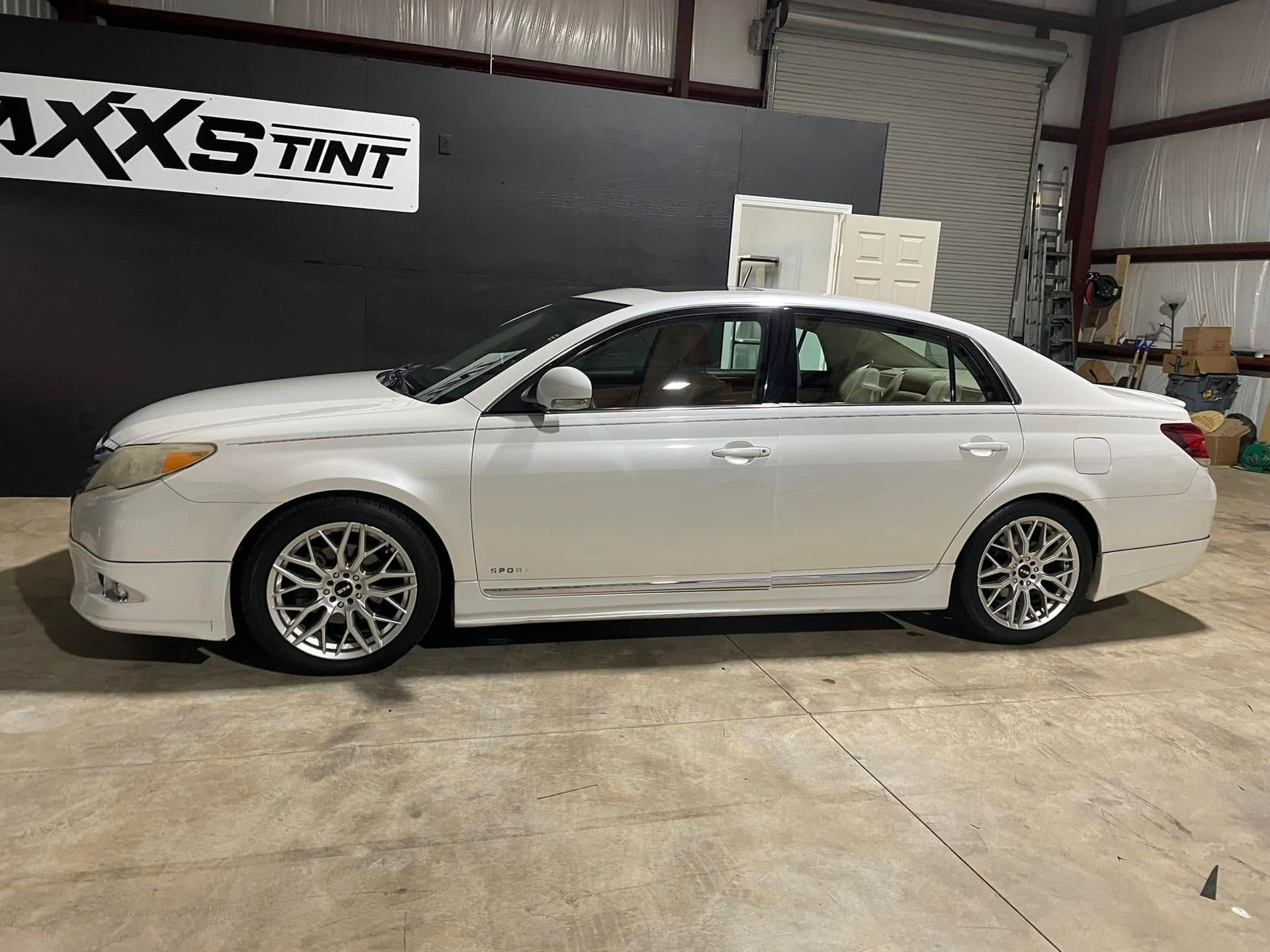 A white toyota avalon is parked in a garage.