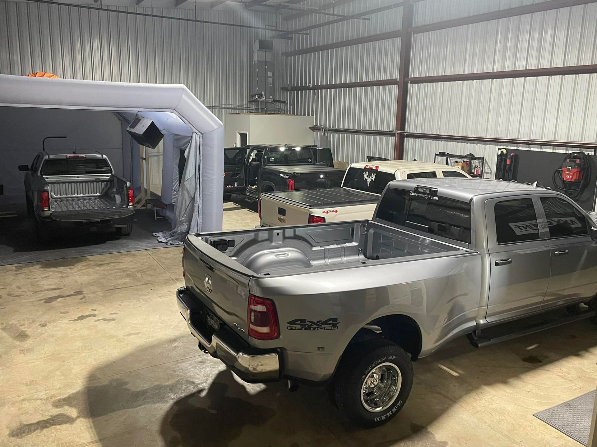 A silver ram truck is parked in a garage.