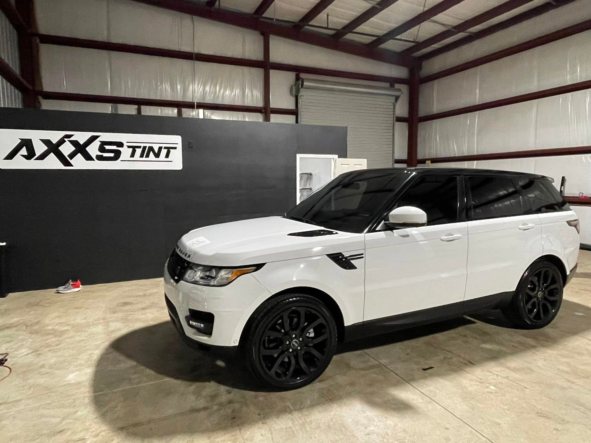A white range rover sport is parked in a garage.