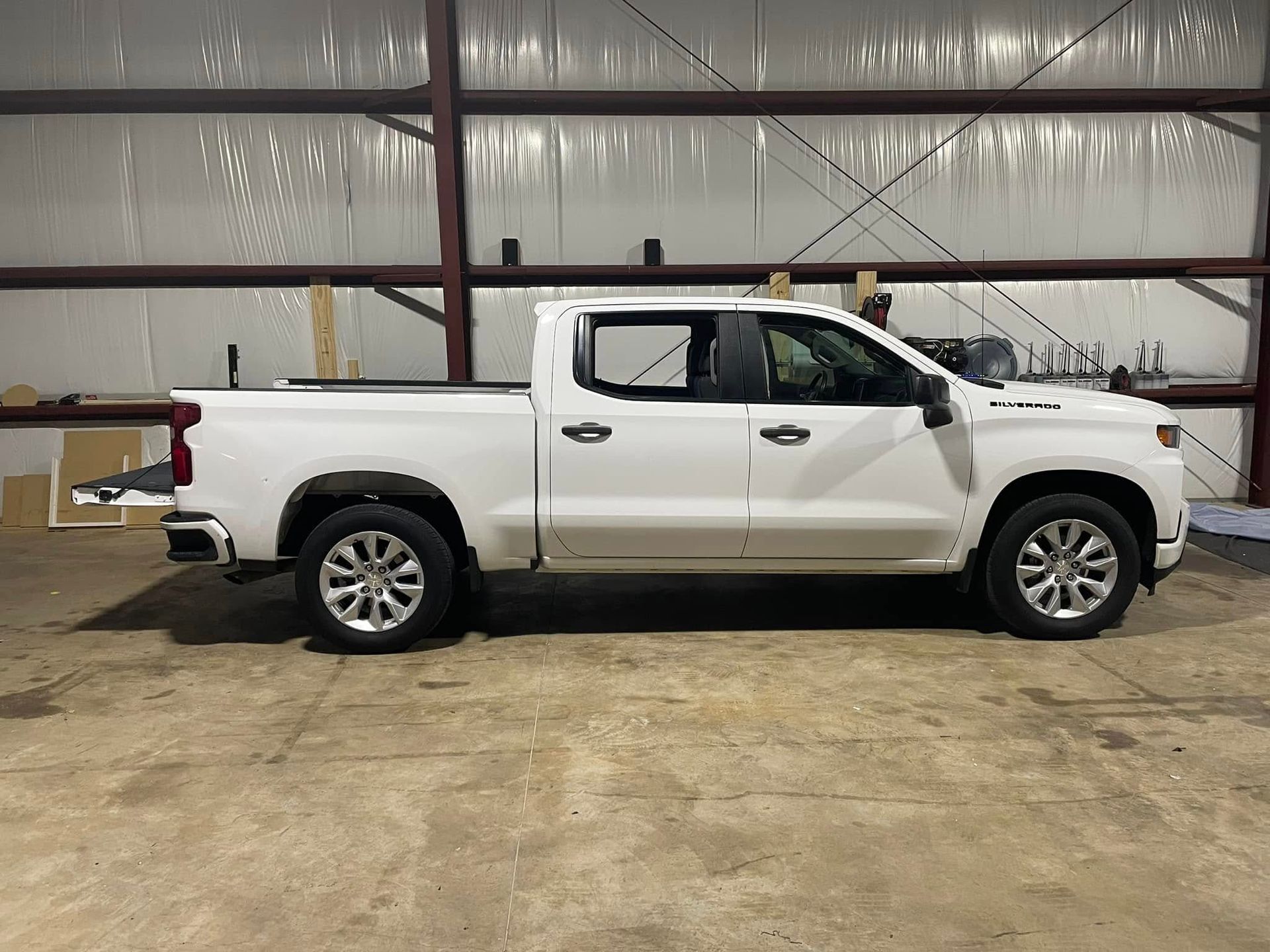 A white pickup truck is parked in a garage.