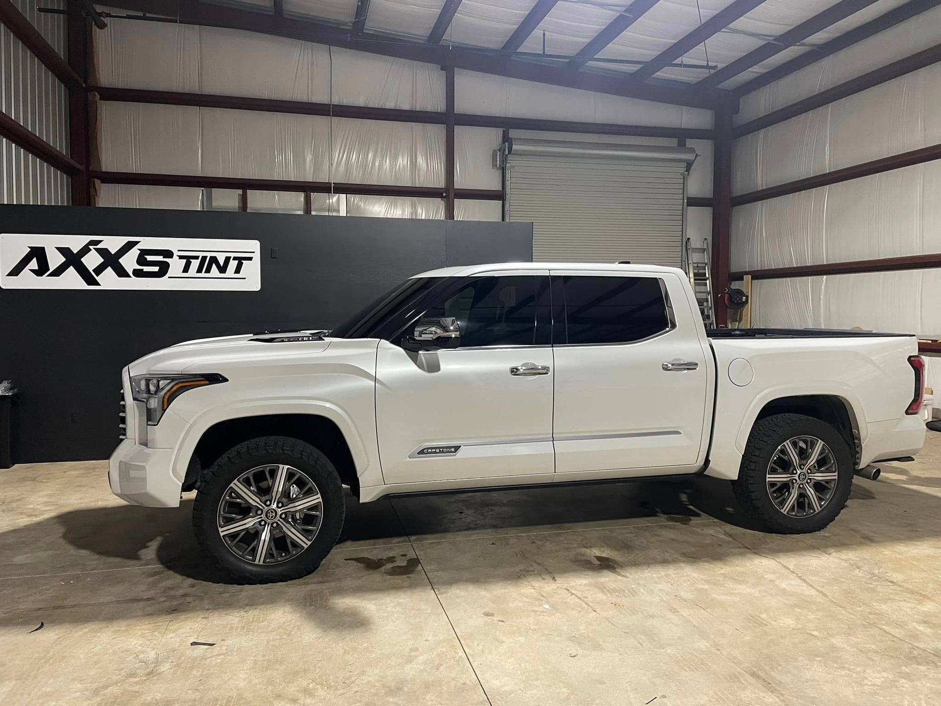 A white truck is parked inside of a building.