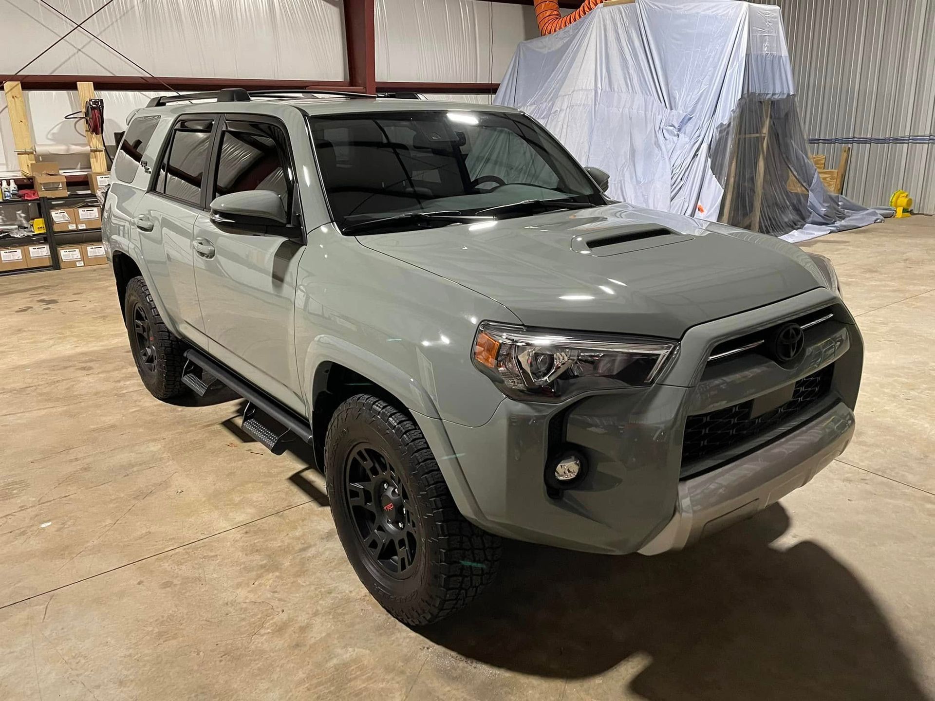 A grey toyota 4runner is parked in a garage.