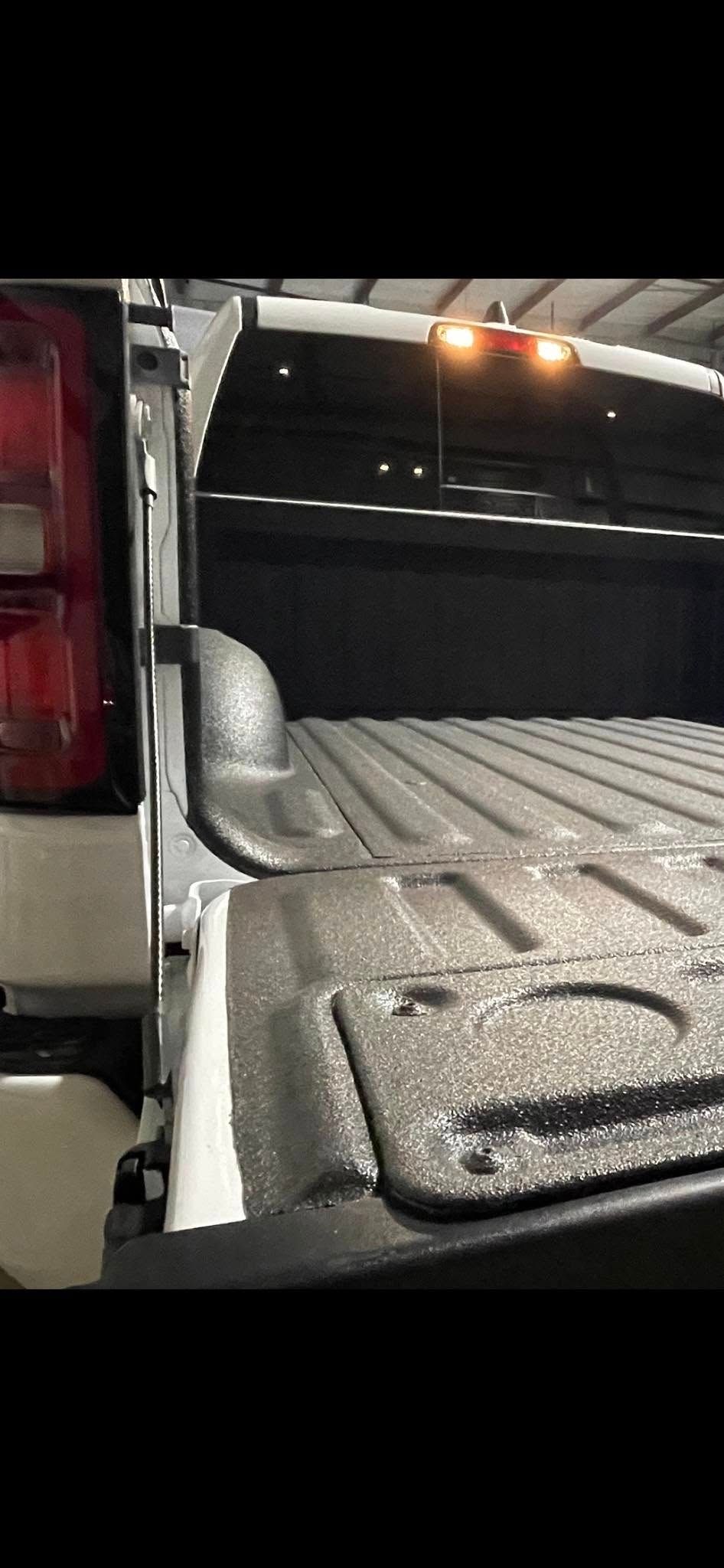 A close up of the back of a truck with the tail light on.