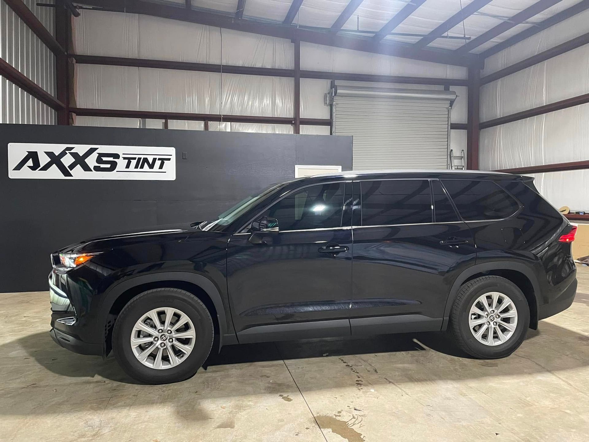 A black suv is parked inside of a building.