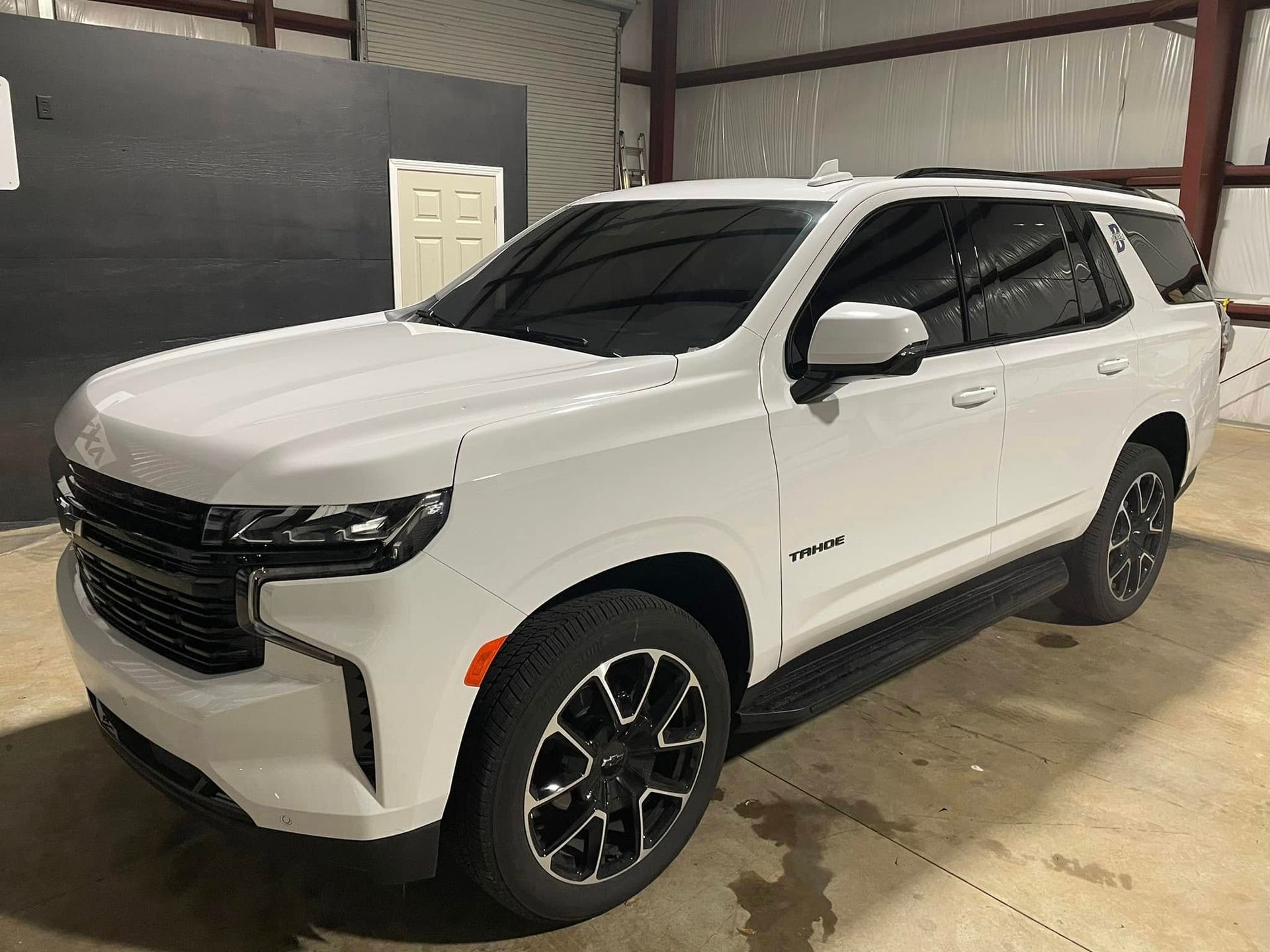 A white suv is parked in a garage.