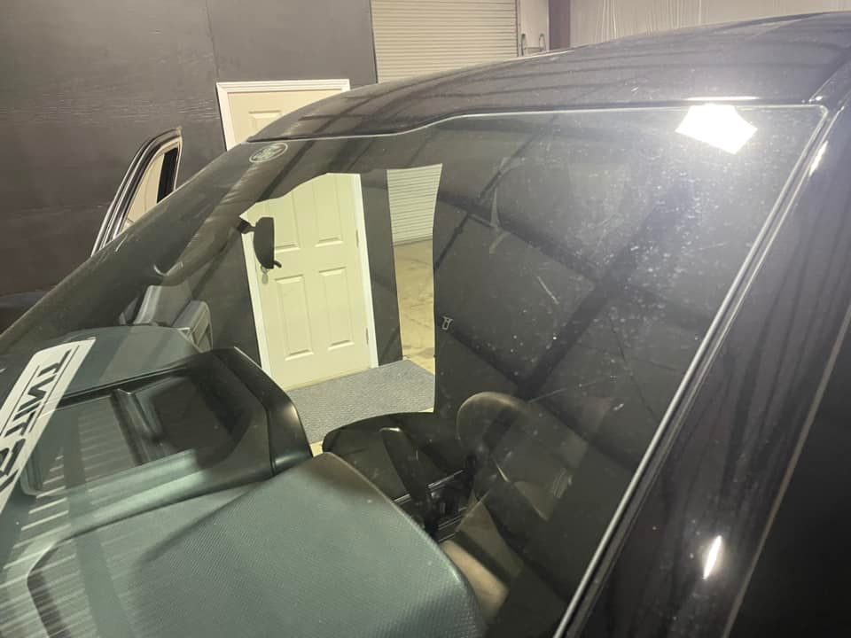 A close up of a car windshield in a garage.