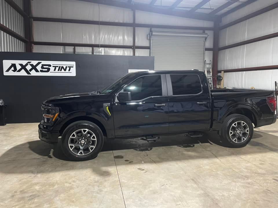 A black pickup truck is parked in a garage.