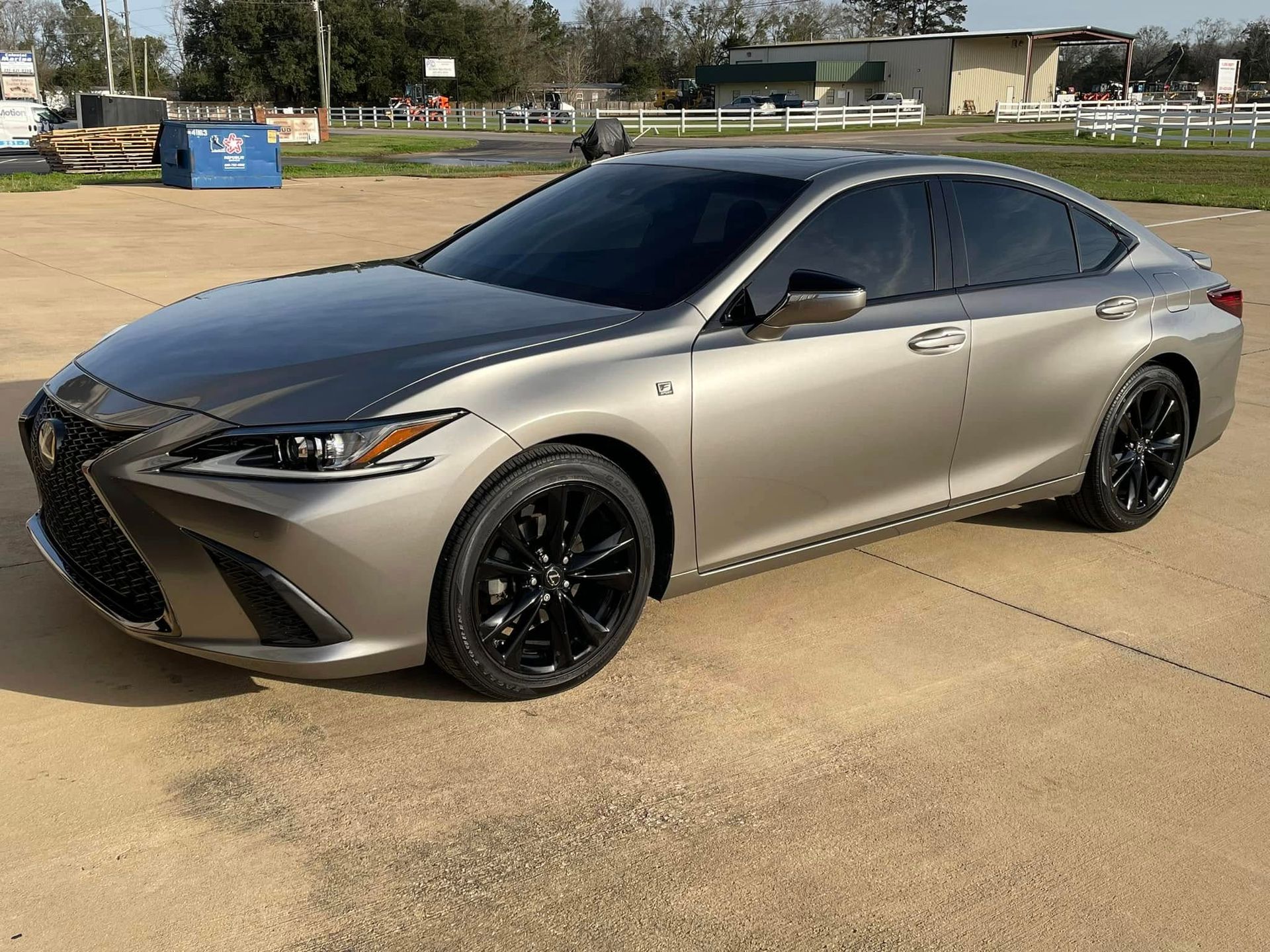 A silver lexus es 350 is parked in a parking lot.