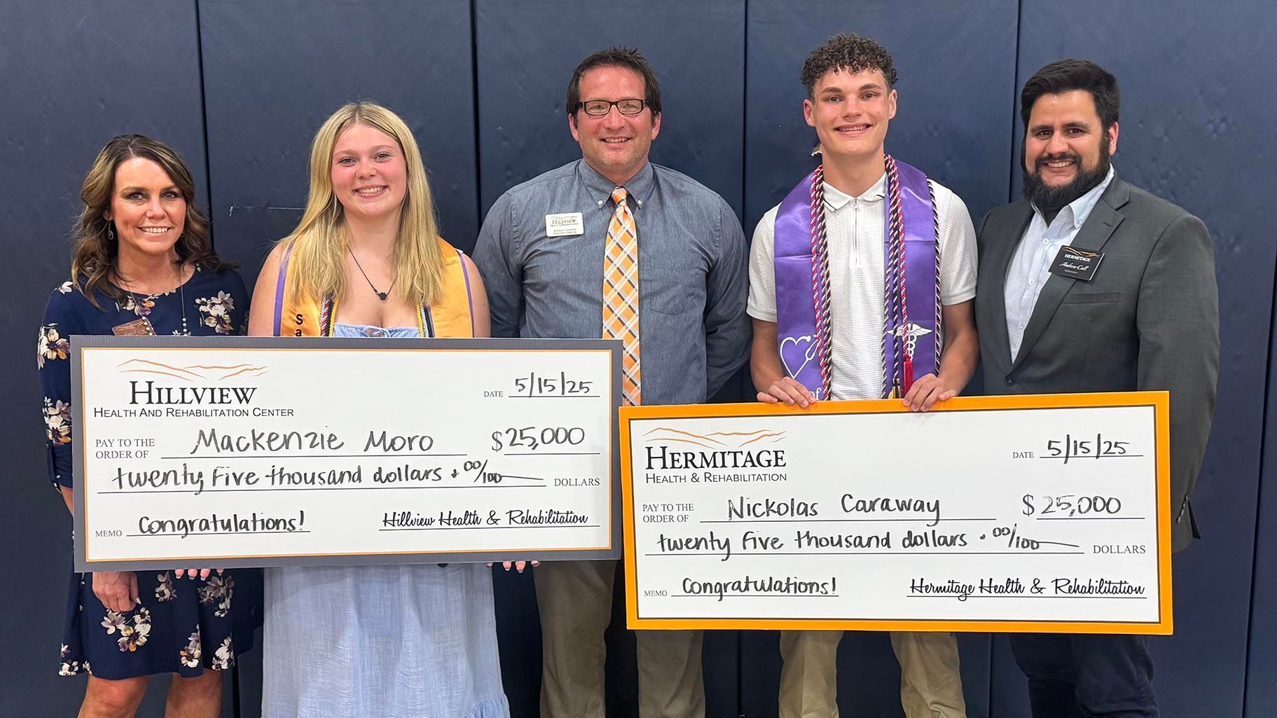 A group of people standing next to each other holding checks.