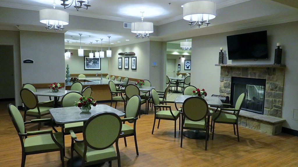 A large room with tables and chairs and a fireplace