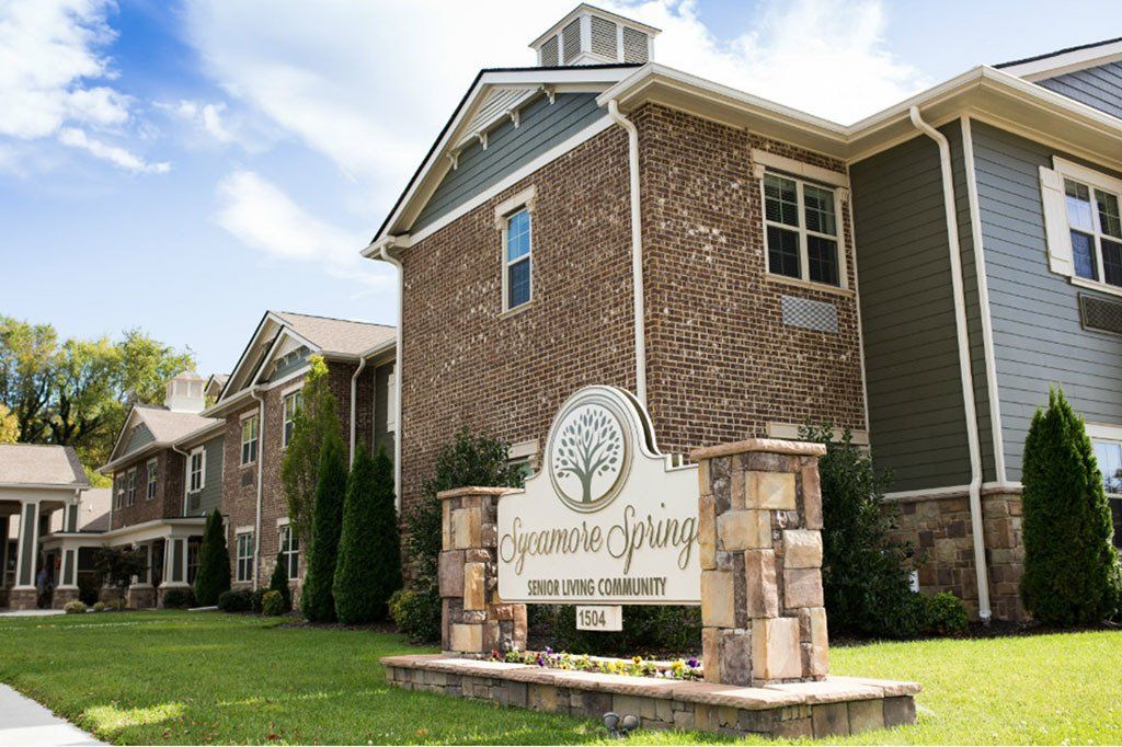 A brick apartment building with a sign in front of it that says brookside springs
