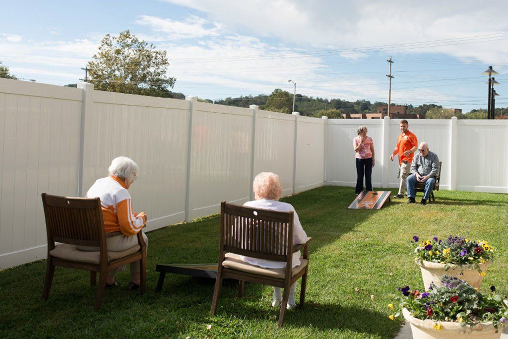 A group of people are playing a game of cornhole in a backyard.