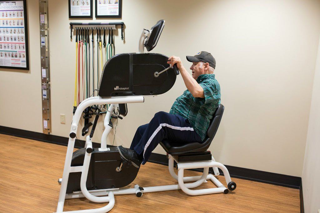 A man is sitting on a bicycle in a gym.