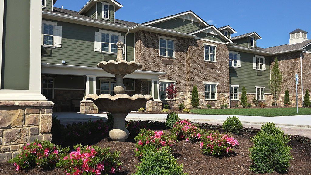 A large apartment building with a fountain in front of it