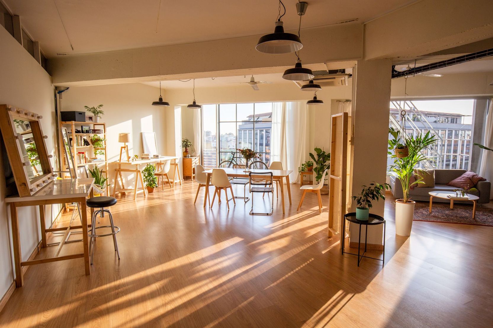 Una grande stanza con pavimenti in legno, tavoli e sedie.