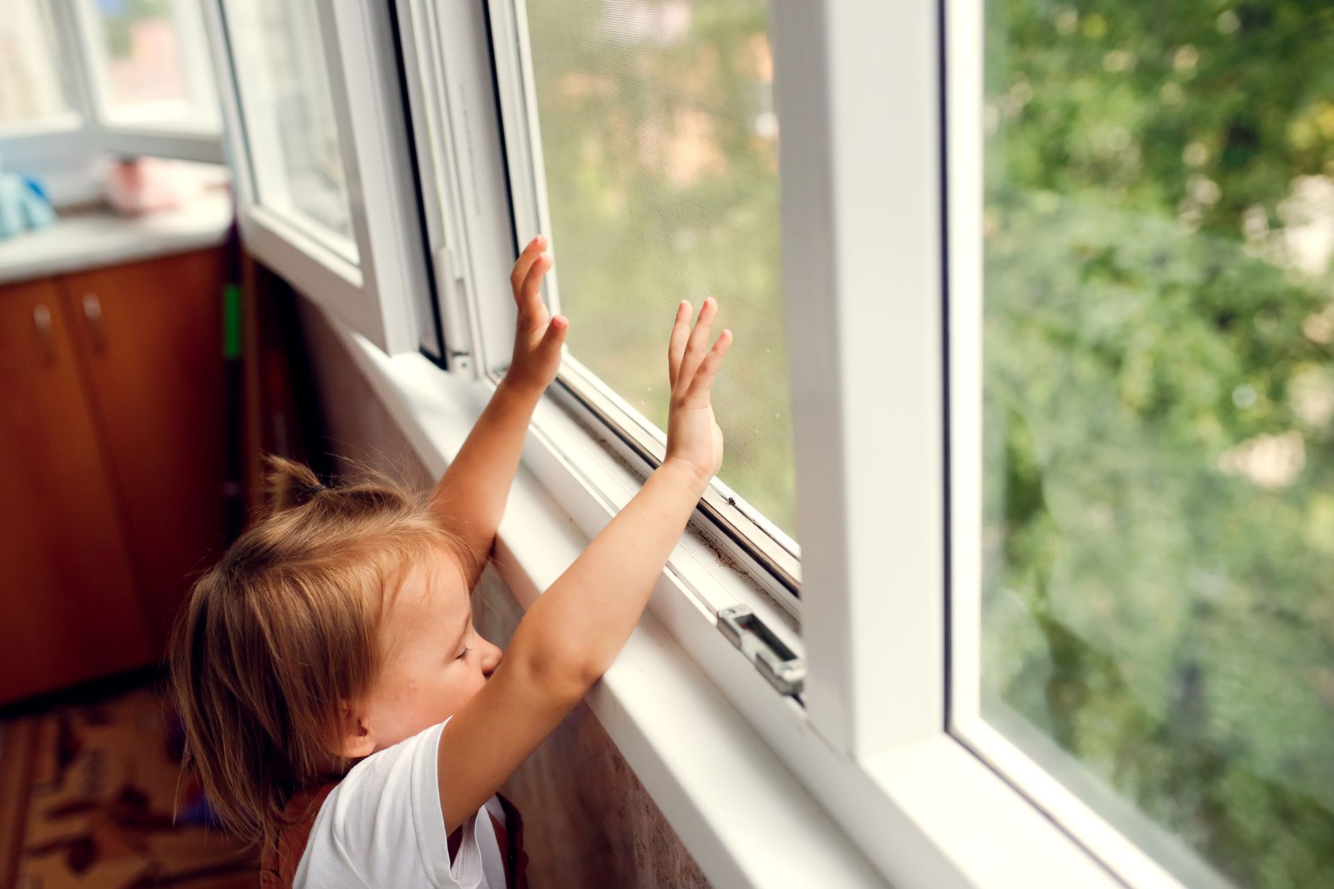 Una bambina guarda fuori dalla finestra.