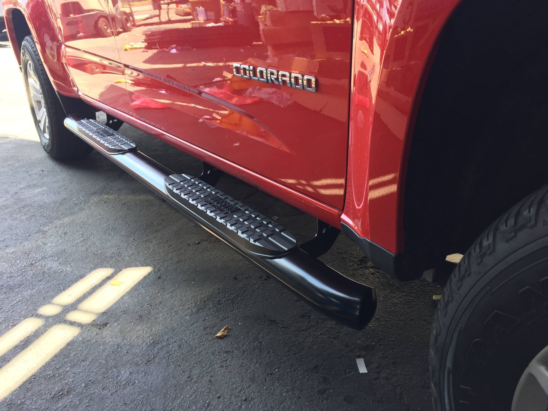 A red colorado truck is parked in a parking lot