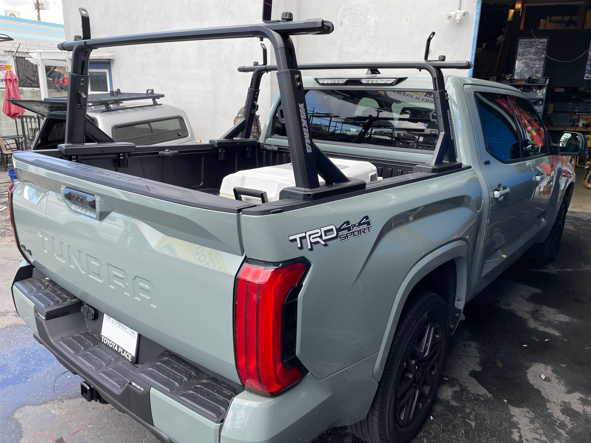 A toyota tundra truck with a rack in the bed is parked in front of a building.