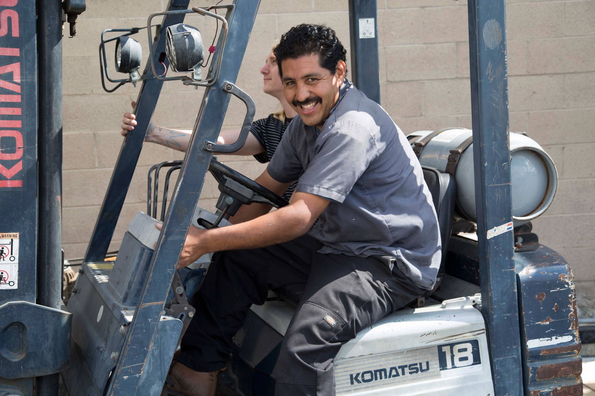 A man is sitting in a komatsu forklift