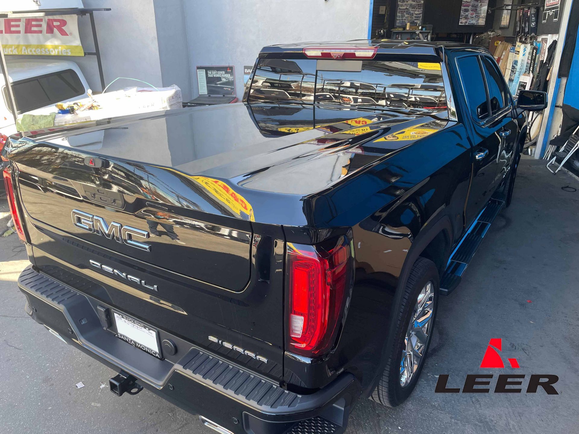 A black gmc truck is parked in front of a building