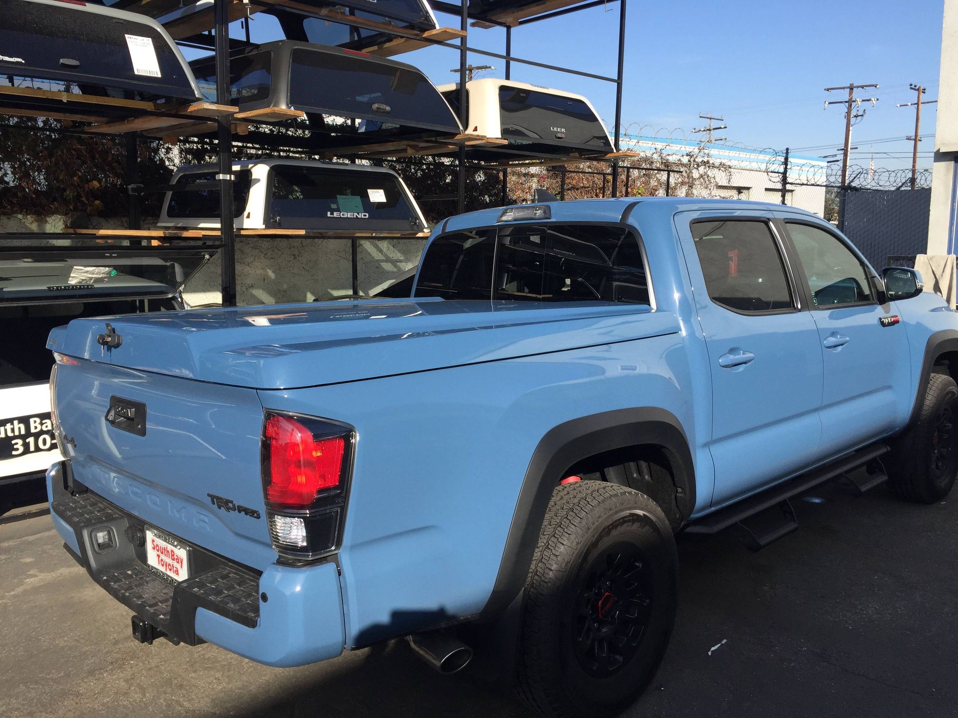 A blue toyota tacoma truck is parked in a parking lot.
