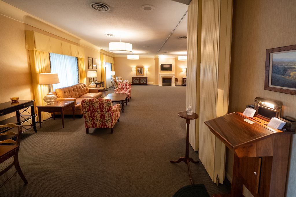 a living room with a couch and chairs and a desk