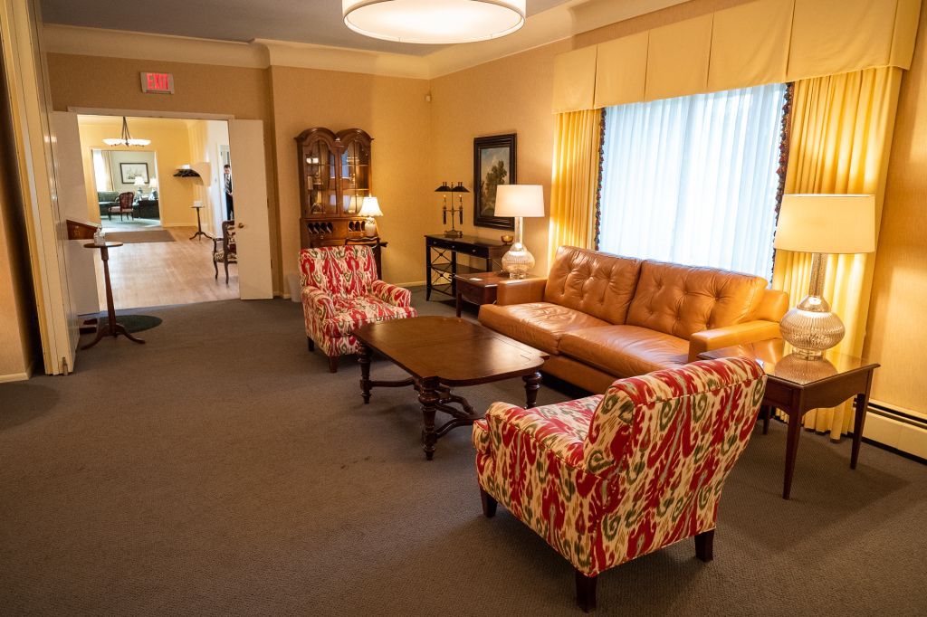 a living room with a couch , chairs , tables and lamps .