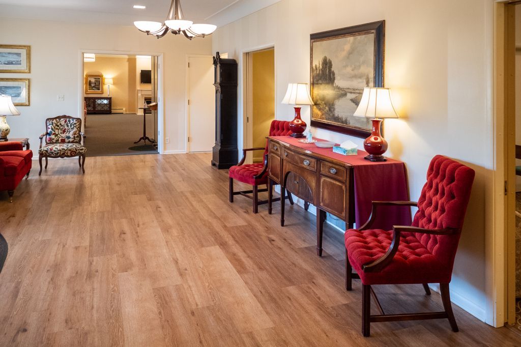 a living room with hardwood floors and red chairs
