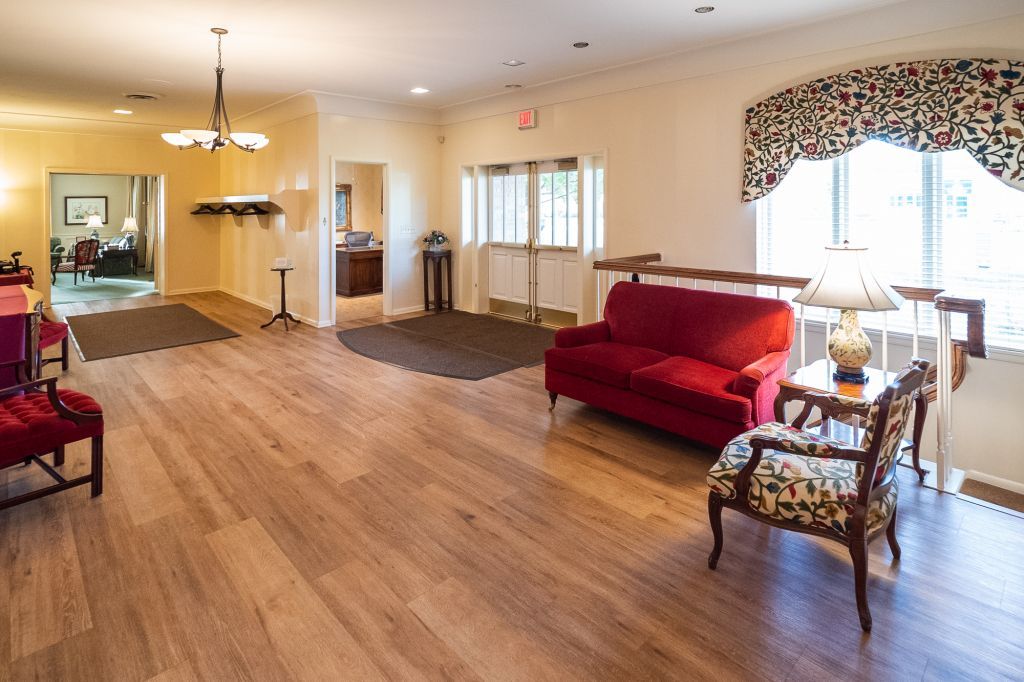 a living room with a red couch and chairs