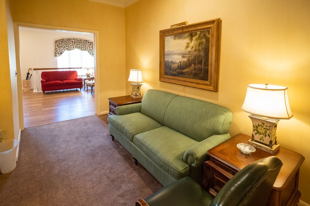 a living room with a green couch and two lamps