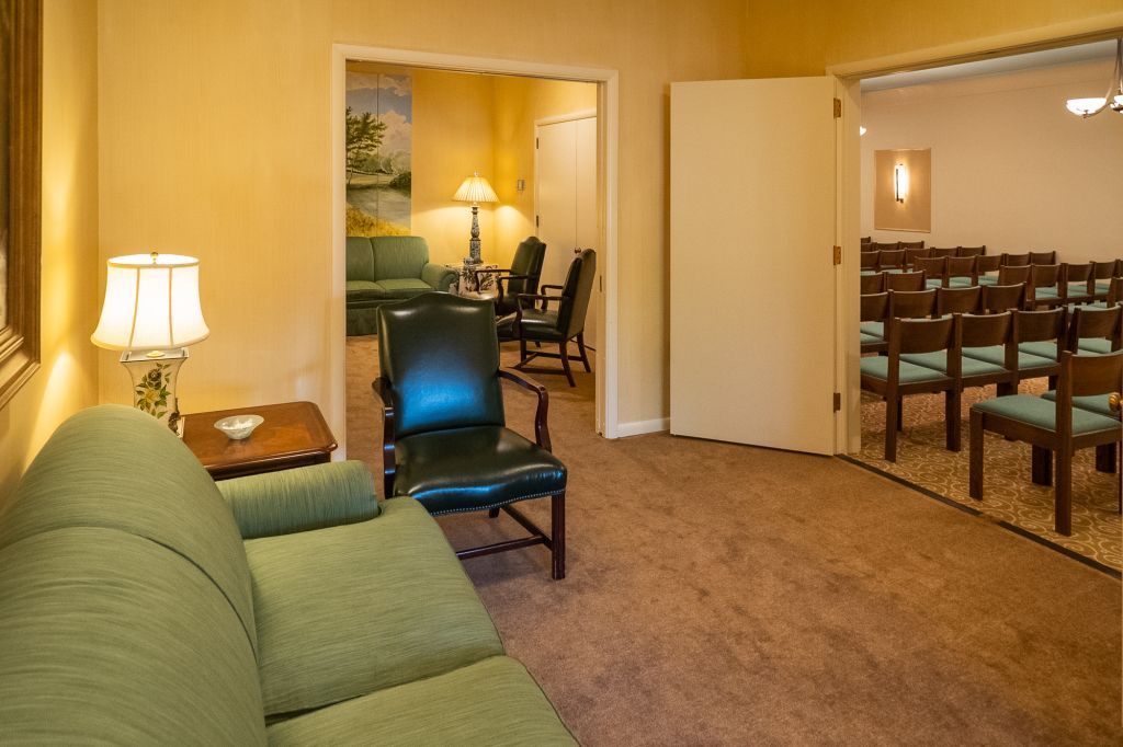 a living room with a green couch and chairs