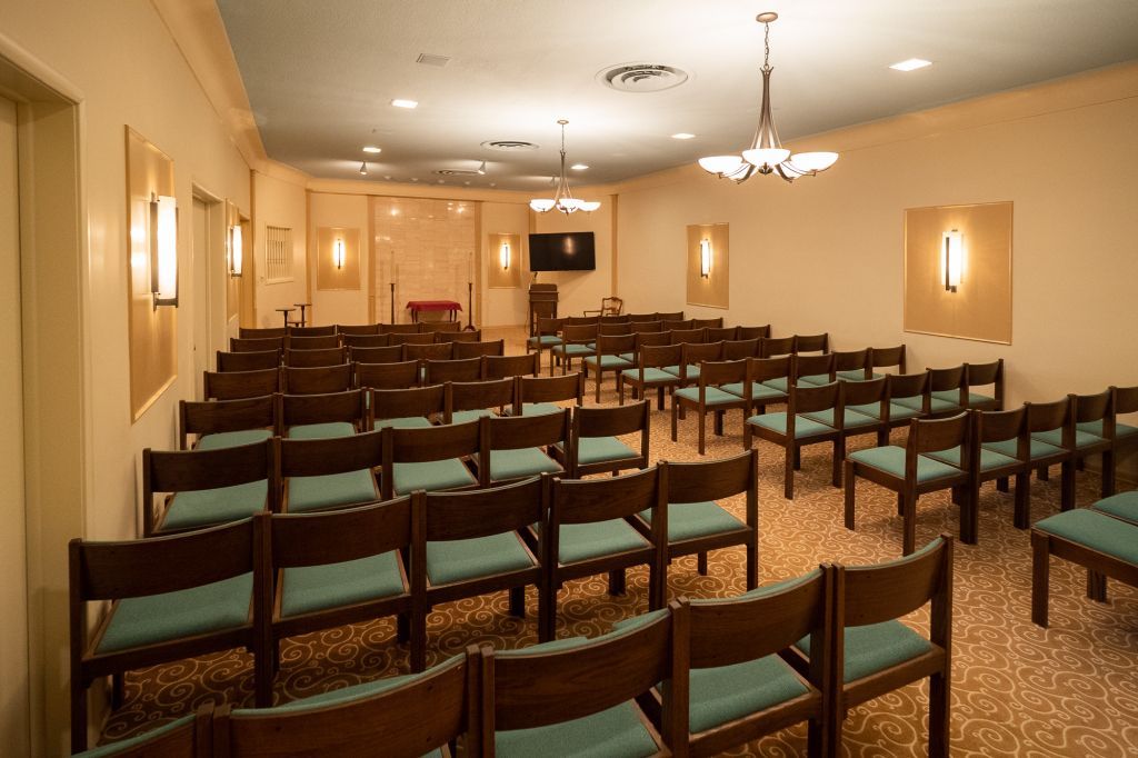 a large room with rows of wooden chairs in it