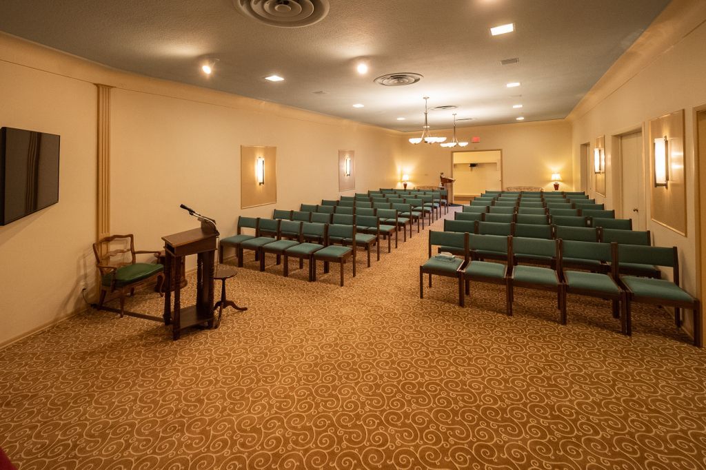 a large room with rows of chairs and a podium .