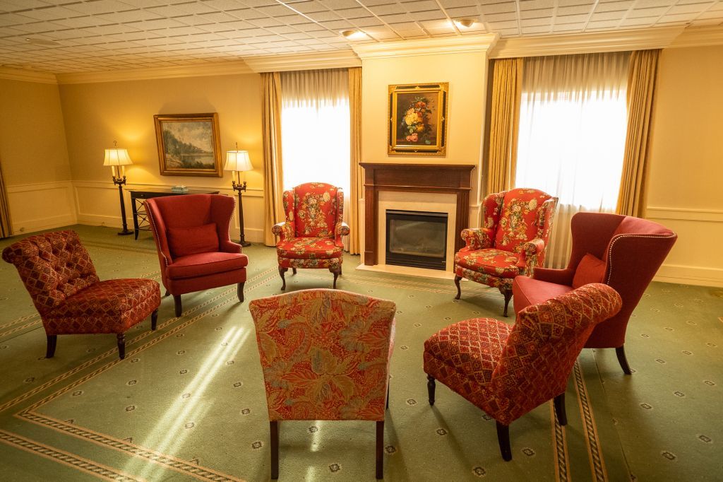 a living room with red chairs and a fireplace .