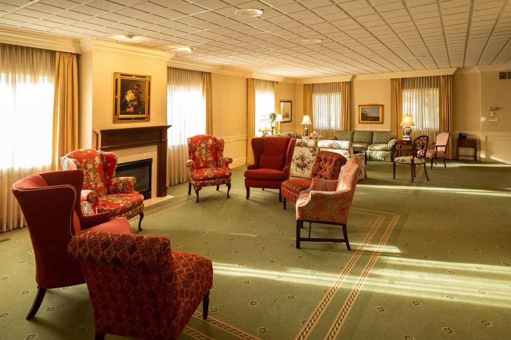 a living room with red chairs and a fireplace .