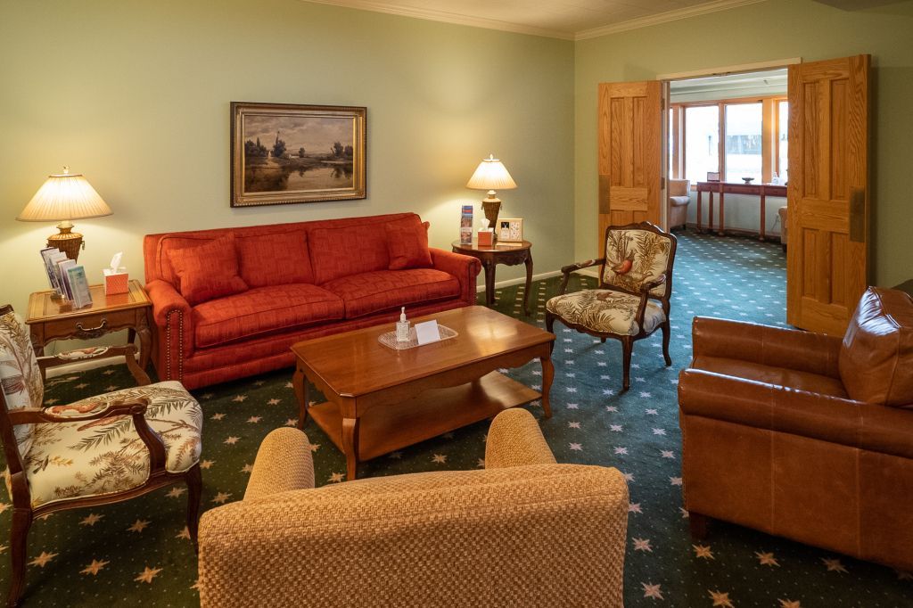 a living room with a red couch and brown chairs