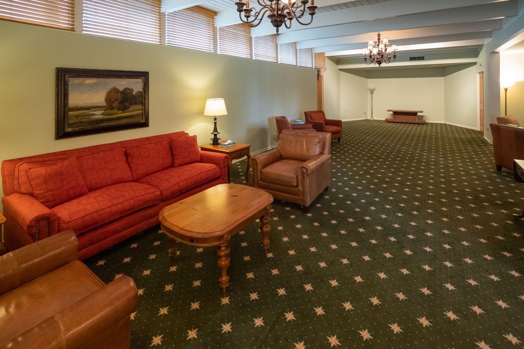 a living room with a red couch and brown chairs