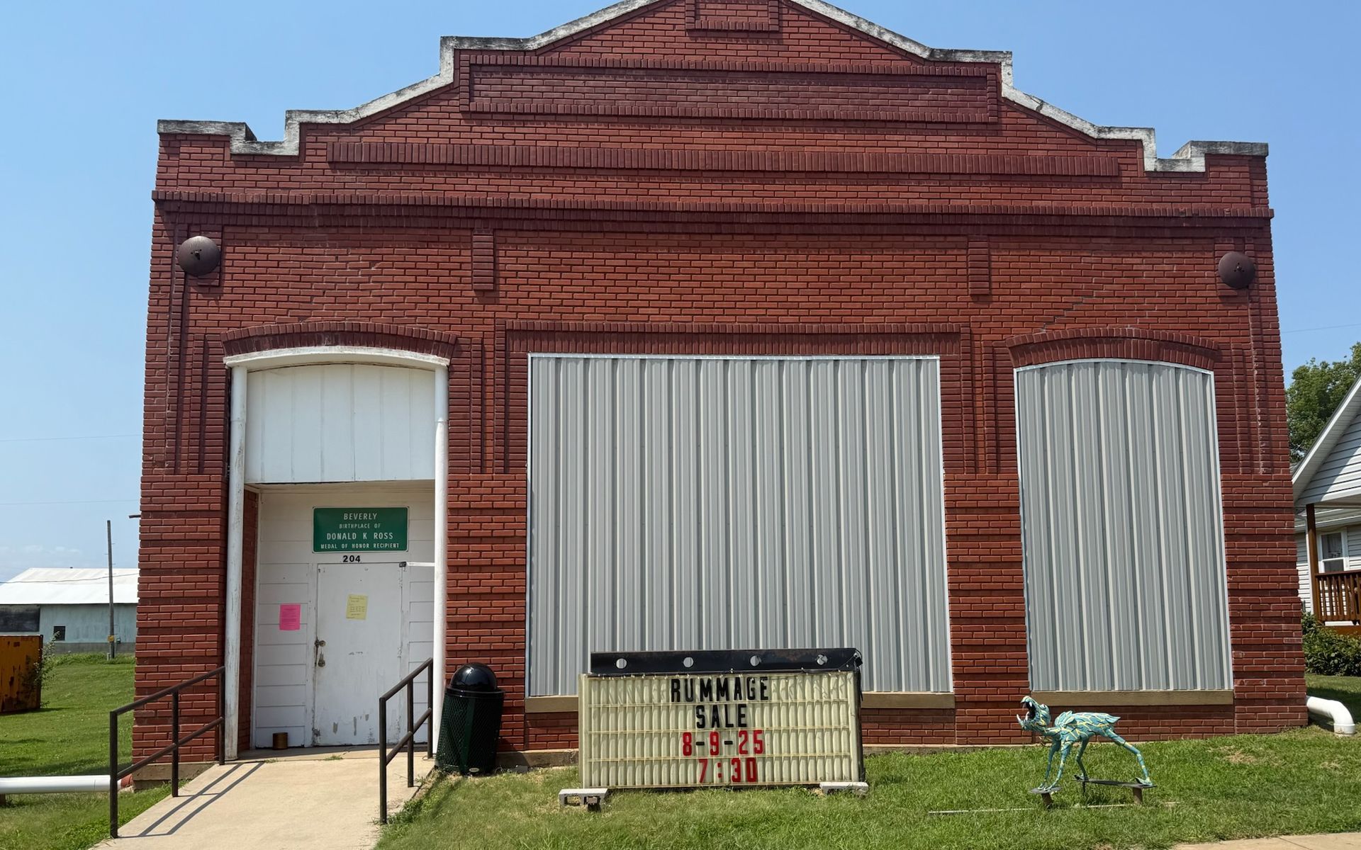 An american flag is flying in front of a building that says simply