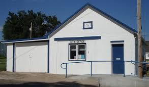 A small white building with a blue door and a blue roof.