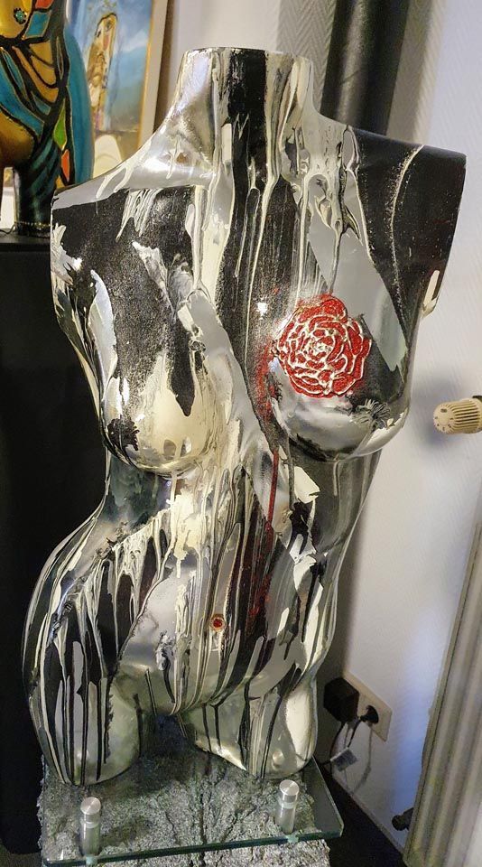 Eine Statue eines Frauentorsos steht auf einem Tisch in einem Raum.