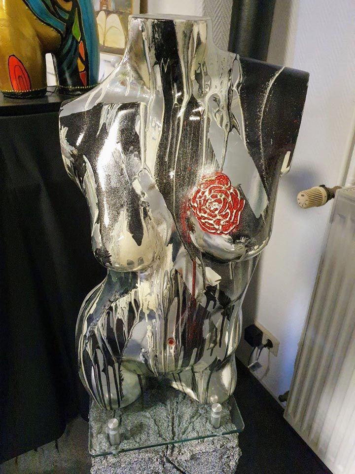 Auf einem Tisch sitzt eine Statue eines Frauentorsos.