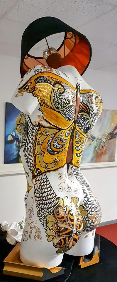 Eine Frauenstatue mit einer Lampe darauf.