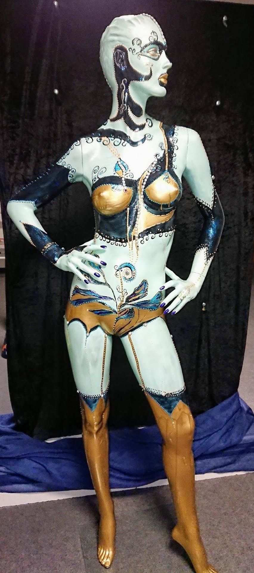 Eine Schaufensterpuppe ist so bemalt, dass sie wie ein Roboter aussieht und steht mit den Händen auf den Hüften.