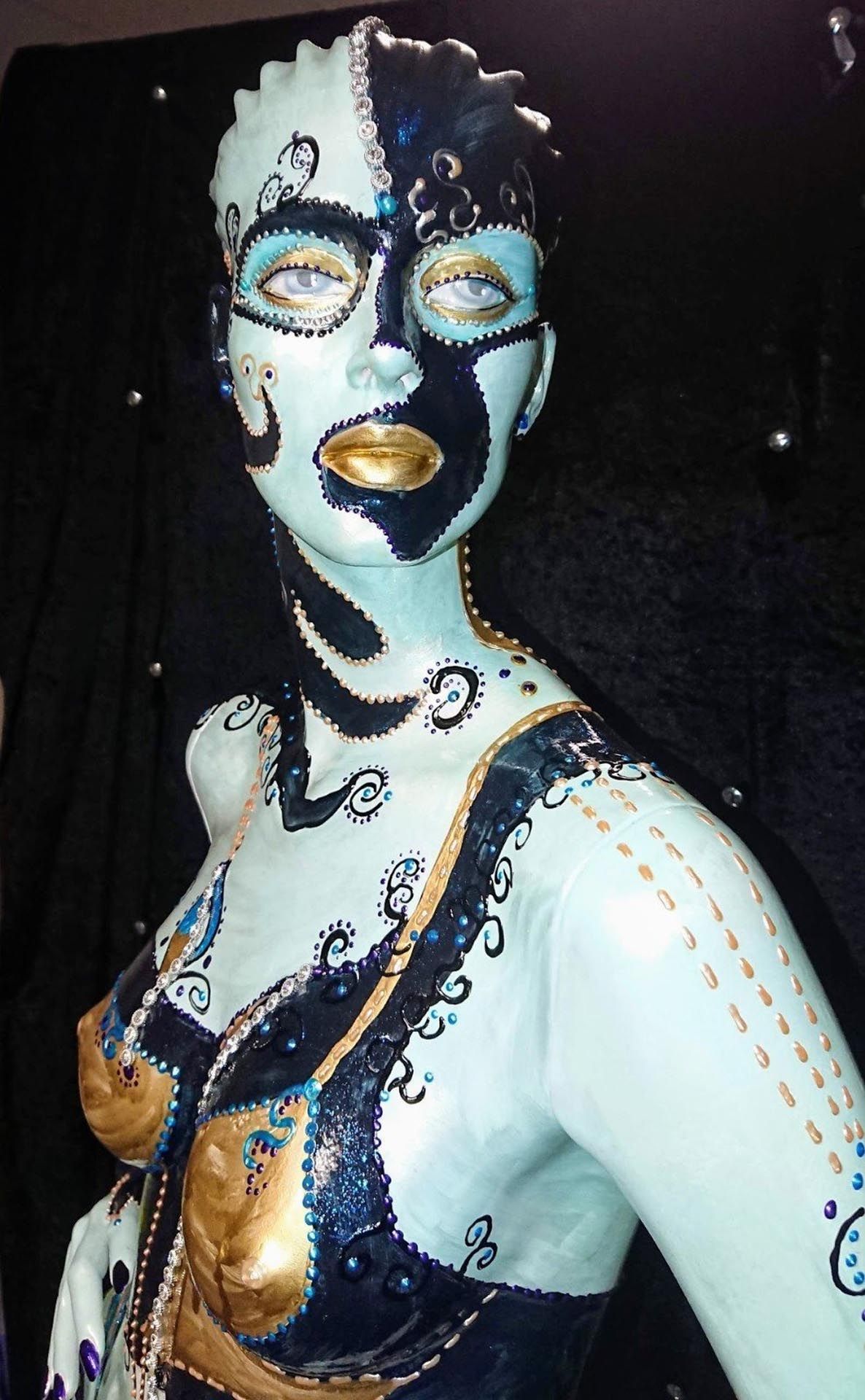 Eine Statue einer Frau mit blauer und schwarzer Farbe im Gesicht