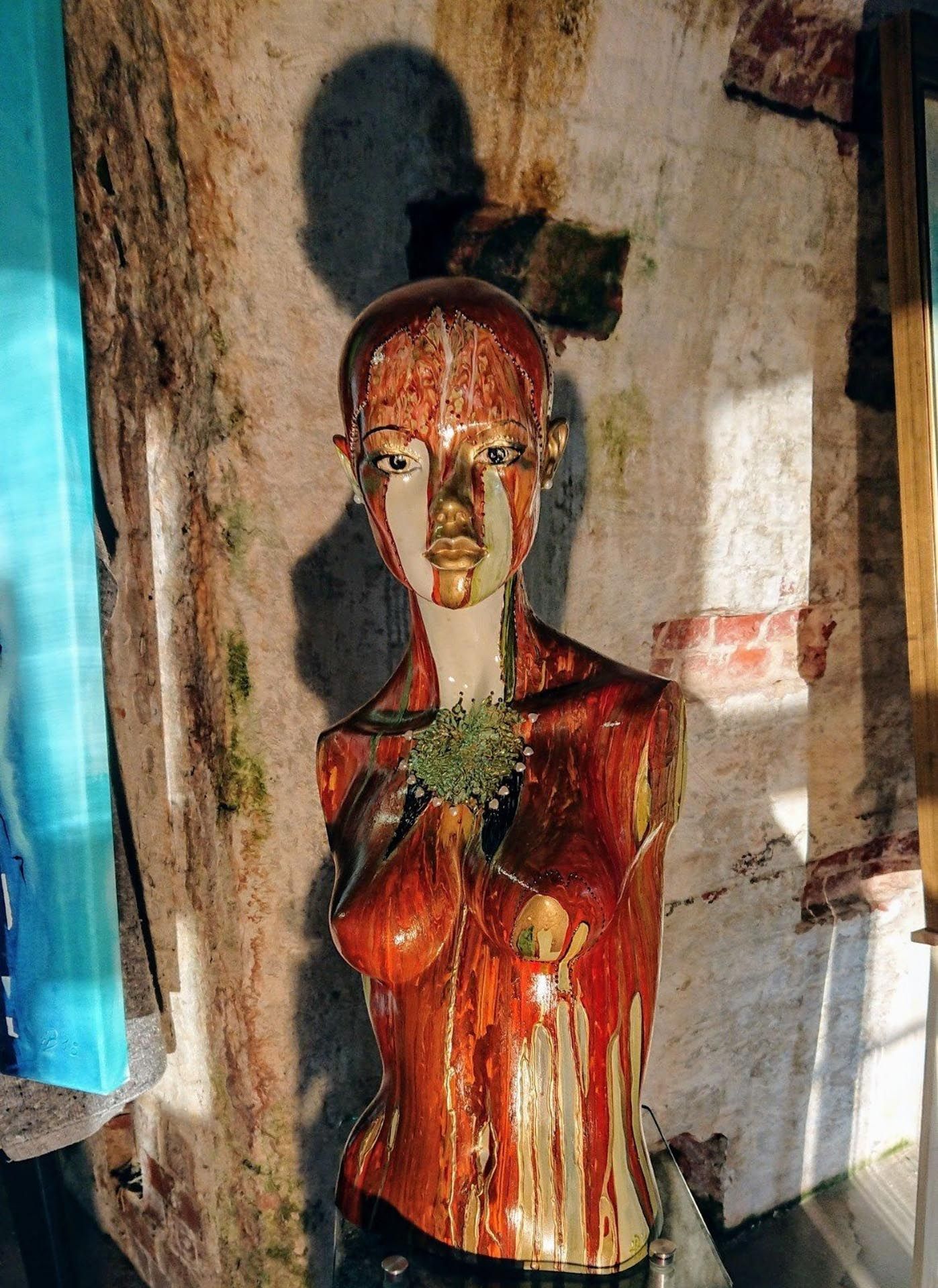 Eine Statue einer Frau, die eine Pflanze in ihren Händen hält.